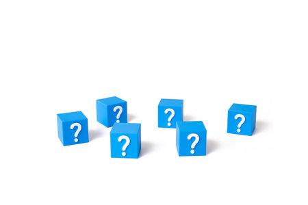 Blocks with question marks are scattered on a white background. Riddles and unknowns. Uncertainty in decisions. Random outcomes. Complexity of choice. Knowledge gaps.の写真素材