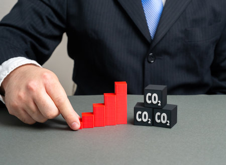 A graph of rising carbon dioxide emissions. A man studies the trend of rising pollution. Global warming, air quality decline, environmental research, ecological crisis, energy policy decisionsの写真素材