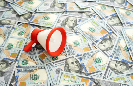 A megaphone against a backdrop of dollars. Pour money into advertising and information dissemination. Concept of marketing investment, digital promotion, brand awareness. Media strategy, PR spendingの写真素材