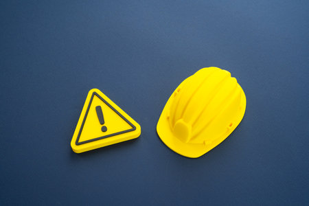 Attention, construction is underway. A construction worker's hard hat and a sign of attention. Repairs and renovations. Concept of industrial safety. Urban planning, renovation projectsの写真素材