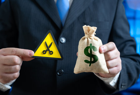 A businessman is forced to cut his budget. Budget sequestration. Saving and cutting costs. Financial crisis, economic slowdown, austerity measures, and expense management.の写真素材
