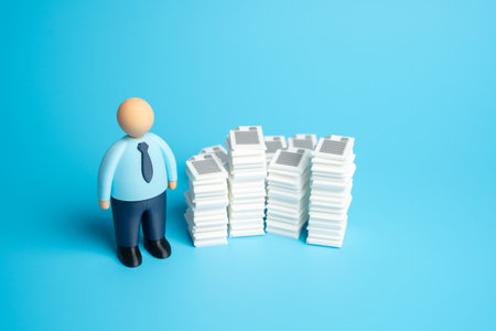 An office worker and stacks of documents and work papers. High bureaucratic burden and extensive paperwork for workers. Concept for administration overload, office routineの写真素材