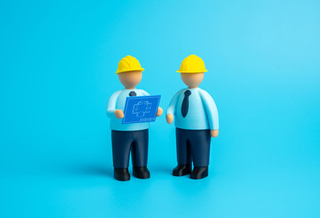 Builders study blueprints. Design and construction. Planning of new projects, teamwork of engineers and architects. Real estate development, technical supervision. Architecture, businessの写真素材