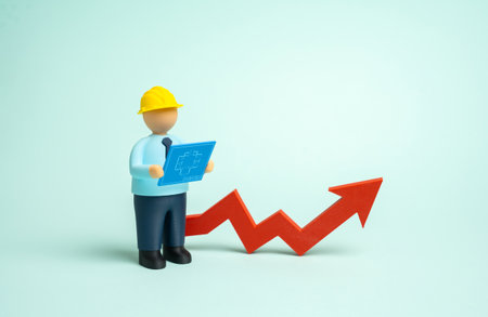 A builder with blueprints and an upward arrow. Increased construction and industrial development. Rising housing prices, market demand, and professional growthの写真素材