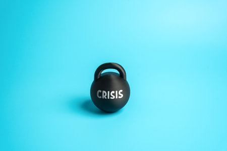 A weight labeled "crisis." Financial difficulties and signs of economic downturn. Symbol of existential crisis and global instability. News, analytics, and psychology of financial stress.の写真素材