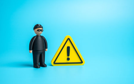 A thief and a sign of attention. Danger of being deceived or robbed. Warning about fraud, data theft, and cybercrime in finance, e-commerce, and online transactionsの写真素材