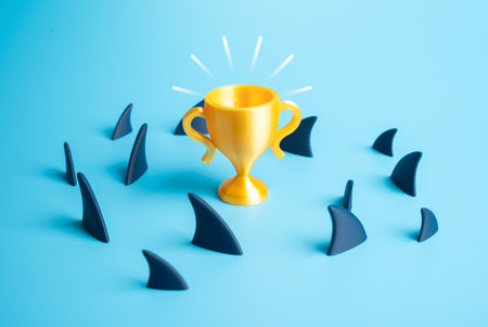 A winner's cup amidst a school of sharks. Dangers and pitfalls on the path to victory and success. Ambition, risk-taking, and survival in a competitive environment. Entrepreneurship, career motivationの写真素材