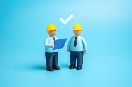 Two builders with blueprints obtain a building permit. Inspectors and engineers approve the drawings and plans. Urban planning, construction process, and architectural project developmentの写真素材