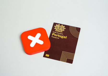Portuguese passport and refusal cross. Ban on entry or exit in Portugal. Ban on entry of citizens into the country of arrival. Refusal to obtain a passport or citizenship.の写真素材