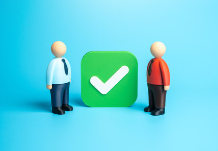 Two office workers near a huge checkbox. Agreement and consent. Conclude a contract. Collaboration, corporate responsibility, and digital confirmation processes in business management.の写真素材