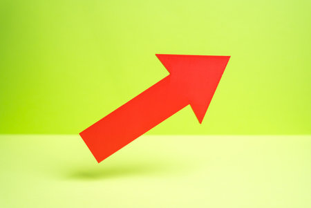 A red arrow pointing upward hovers on a green background. Concept of growth and expansion. Economic rise and business performance. Success metrics. Financial forecasting.の写真素材