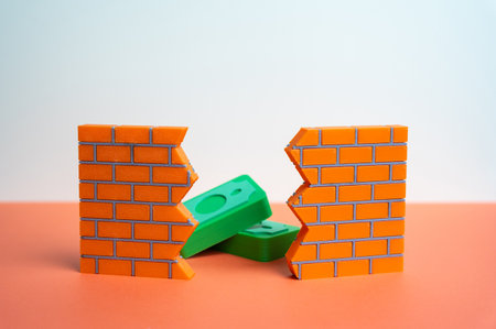 Money is visible through a gap in the wall. Bureaucracy and corruption. Overcoming barriers through trade and mutual benefit. Shadow influence, hidden payments and economic obstacles.の写真素材