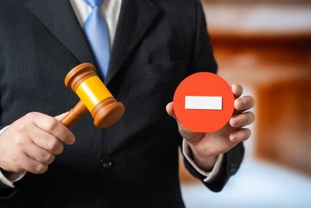 An official with a judge's gavel and a stop sign. New prohibitions and laws. Regulatory updates, compliance notifications and government policy announcements.の写真素材