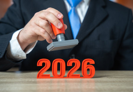 The year 2026 and a businessman with a stamp in hand. Reports and closings before the start of the...