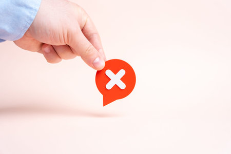 A hand holding a comment cloud with an X signifying rejection. Saying no and refusing to cooperate...