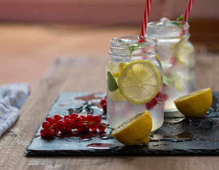 Two lemonades with lemons and mint on wooden table backgroundの写真素材