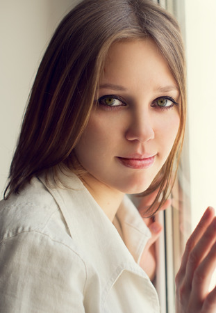 Beautiful girl looking out of the window, the houseの写真素材