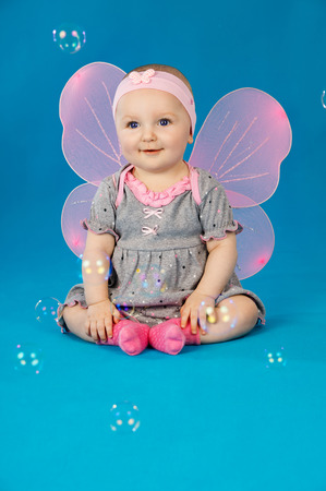 baby in costume butterflies with soap bubbles