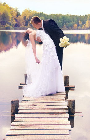 young couple kissing on the bridge on natureの写真素材
