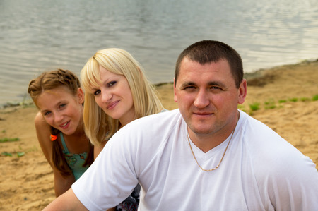 family sitting by the sea on the natureの写真素材