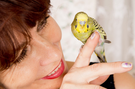 in age woman with a parrot in the houseの写真素材