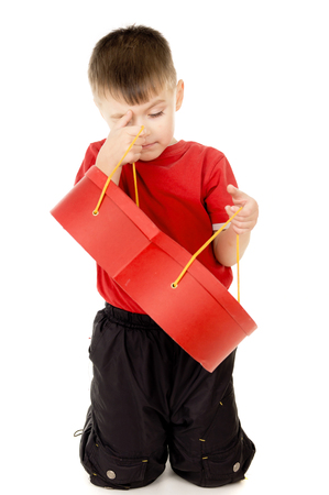 a small child is holding a box in the form of heart isolated on white backgroundの写真素材