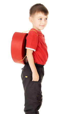 a small child stand is with a backpack in the form of heart isolated on white backgroundの写真素材