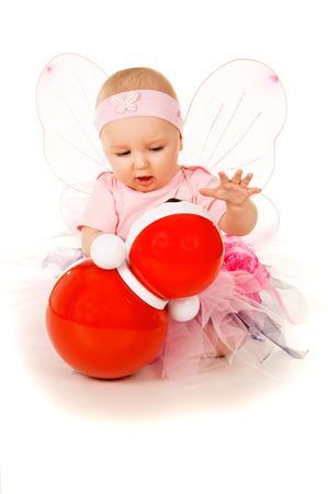 little girl in a suit playing with a toy isolatedの写真素材