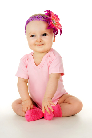 little girl with a flower on her head sittingの写真素材