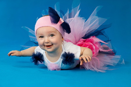 little girl lying on a blue backgroundの写真素材