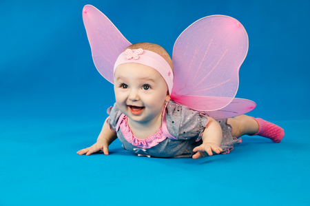 happy baby with wings on blue backgroundの写真素材
