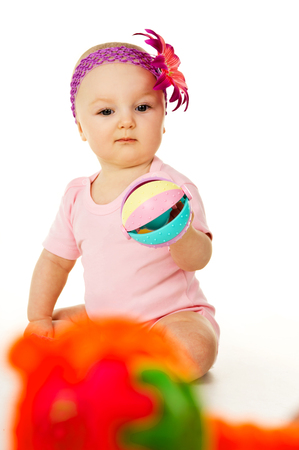 beautiful baby girl with a flower playsの写真素材