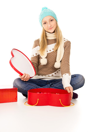 girl in winter hat sitting with gift boxes isolatedの写真素材