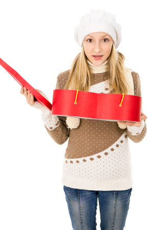 Girl in winter cap with a gift isolatedの写真素材