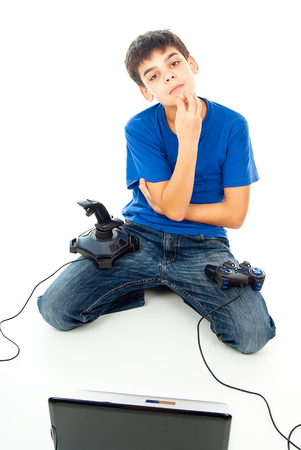 Boy thinks the computer and with two joysticksの写真素材