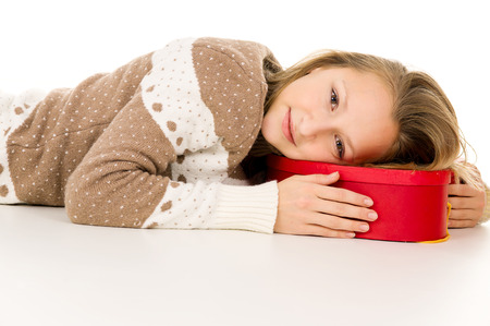 beautiful girl lies on a gift box isolatedの写真素材