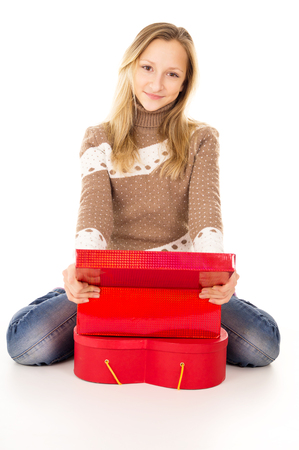 Teen girl sitting near the gift boxes isolatedの写真素材