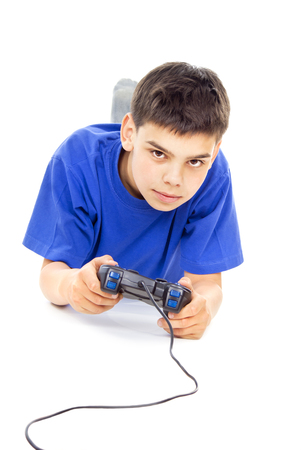 boy plays on the joystick while lying on the floorの写真素材