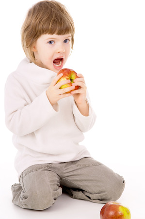 the little girl leads a healthy way of life, and eat apples isolated on white backgroundの写真素材