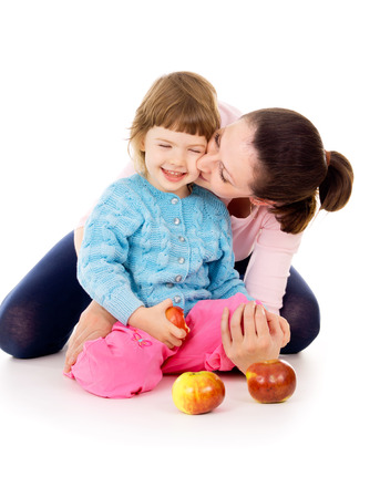 mom with daughter having a healthy way of life, and eat apples isolated on white backgroundの写真素材