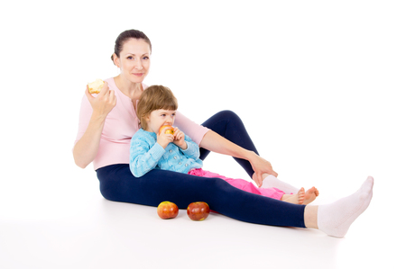 mother with a child eat apples isolated on white backgroundの写真素材