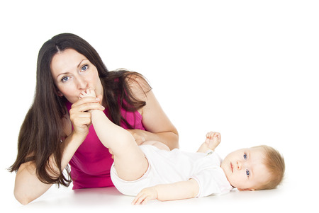 beautiful mother kissing baby legの写真素材