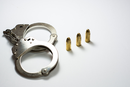 Handcuff and bullets isolated on whiteの写真素材