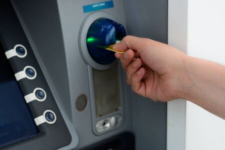 Business man put his credit card at the ATM
