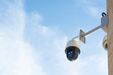 Surveillance camera against blue sky