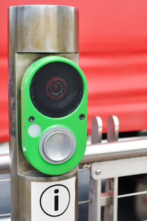 Public transport information speaker mounted on post with big round metallic button and info signの写真素材