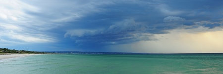 Panorama of front thunderstorm clouds in windy conditions approaching sandy beach at Port Philip Bay, Melbourne Australiaの写真素材
