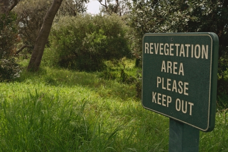 Large green revegetation area please keep out sign in public park surrounded with grass and tress in Victoria, Australiaのeditorial素材