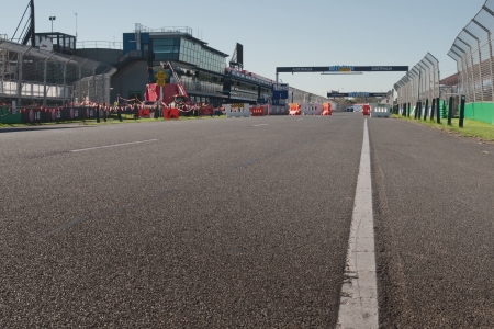 White line at asphalt at construction zone near pit stop with workers, lifts and cranes at Melbourne Formula One Grand Prix のeditorial素材