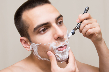 The man is shaving with foam machineの写真素材